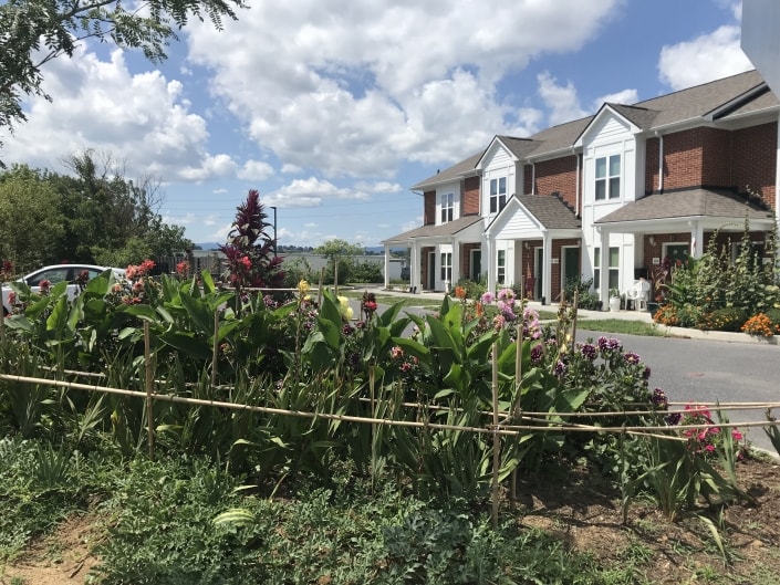 Landscaped gardens in front of brick residential homes at a permanent supportive housing community.
