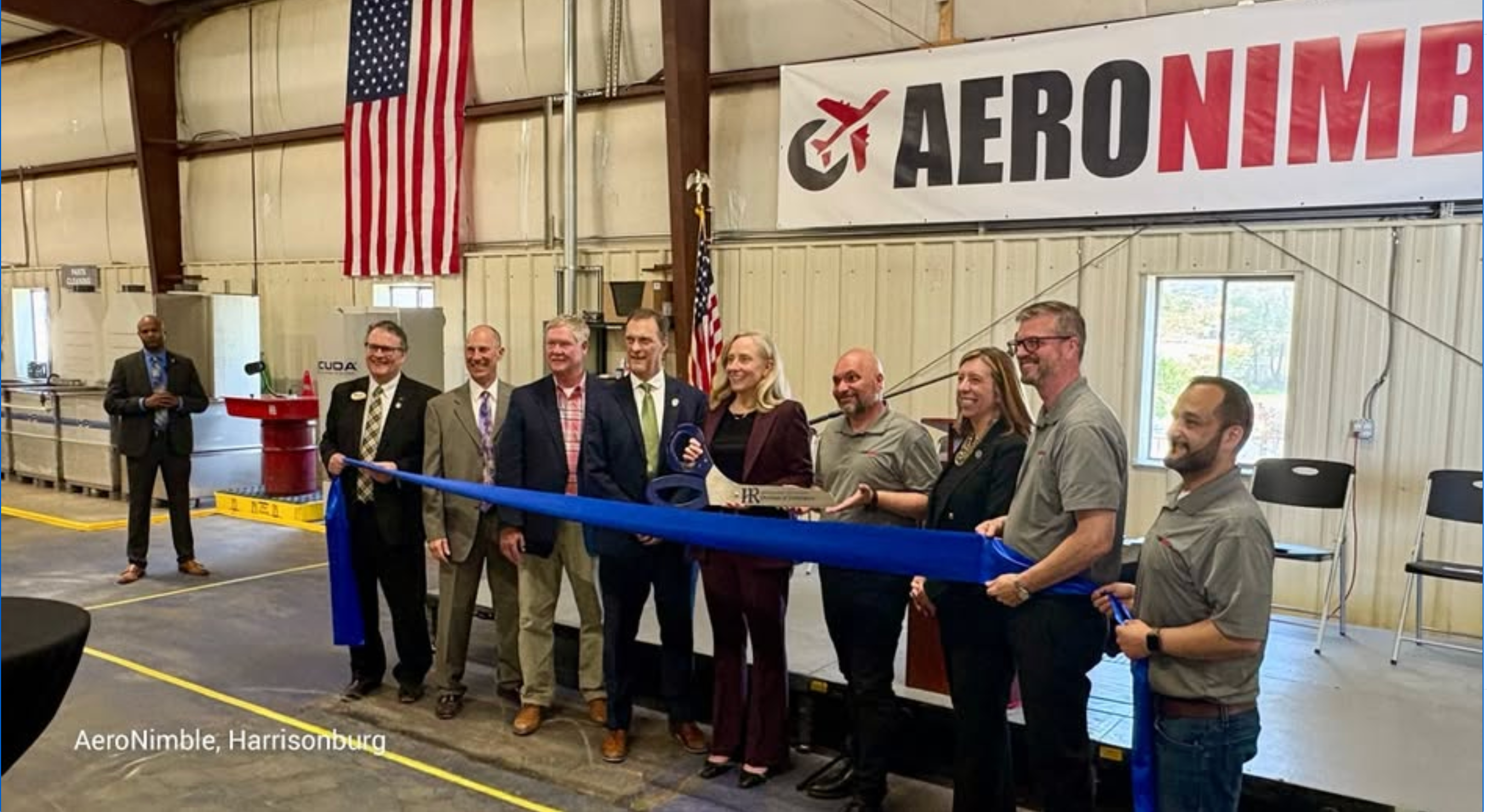 AeroNimble representatives, local officials, and community members at a ribbon-cutting inside an aviation facility in Harrisonburg.
